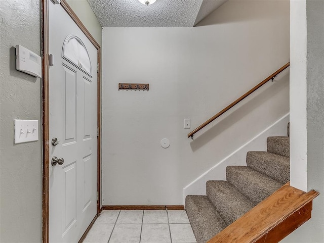 tiled foyer featuring a textured ceiling