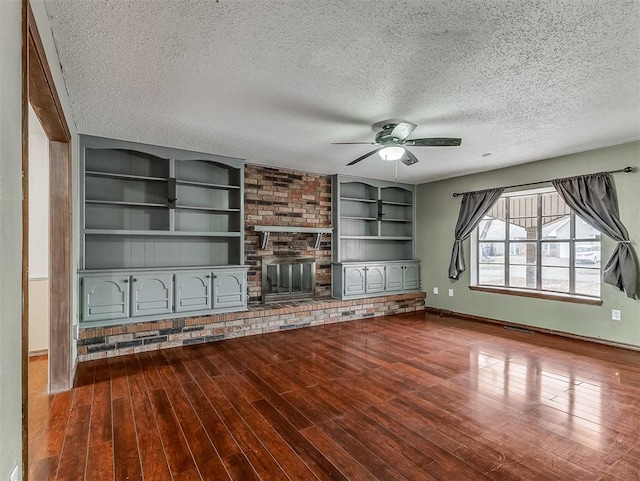 unfurnished living room featuring hardwood / wood-style flooring, ceiling fan, a textured ceiling, and a fireplace