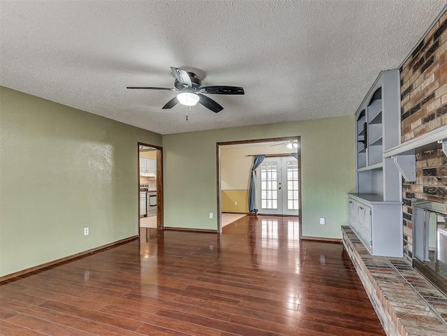 unfurnished living room with a fireplace, dark wood-type flooring, french doors, and a textured ceiling