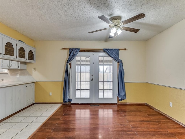 interior space featuring french doors, ceiling fan, light hardwood / wood-style flooring, and a textured ceiling