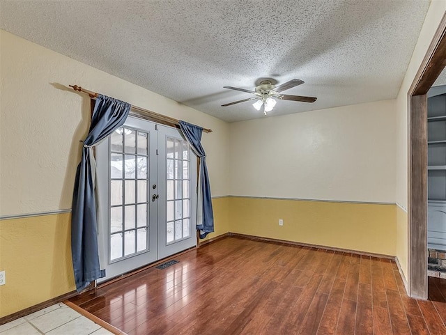 spare room with french doors, ceiling fan, a textured ceiling, and hardwood / wood-style flooring