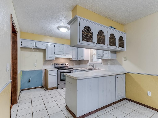 kitchen with sink, tasteful backsplash, stainless steel electric range, light tile patterned floors, and kitchen peninsula