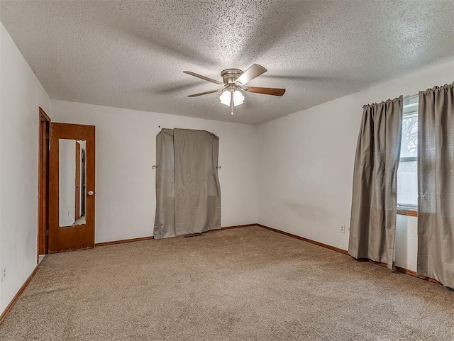 spare room with ceiling fan, carpet flooring, and a textured ceiling