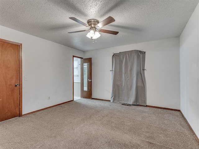 carpeted spare room featuring ceiling fan and a textured ceiling