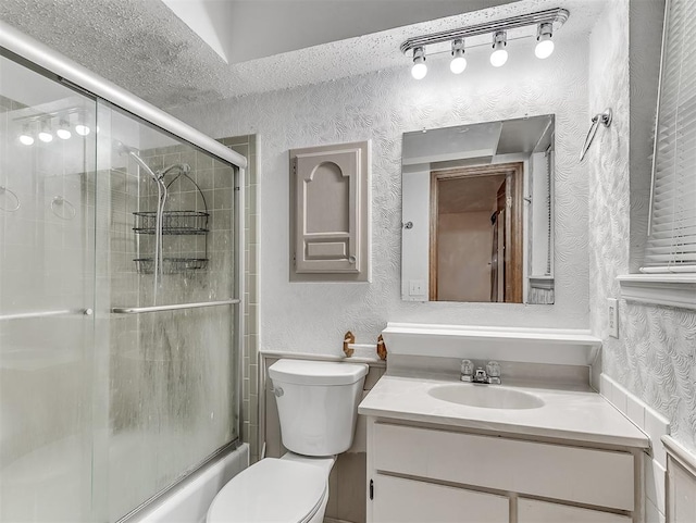 full bathroom with vanity, a textured ceiling, enclosed tub / shower combo, and toilet