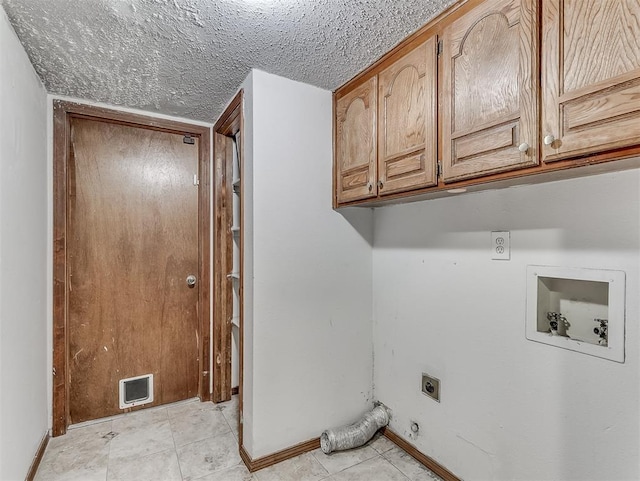 laundry area featuring cabinets, washer hookup, a textured ceiling, light tile patterned flooring, and hookup for an electric dryer