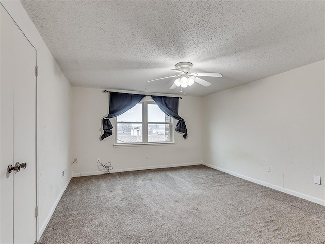 carpeted spare room featuring ceiling fan and a textured ceiling