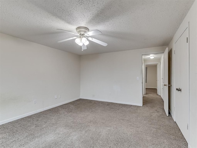 empty room with ceiling fan, light carpet, and a textured ceiling