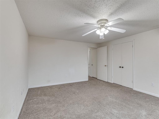 unfurnished bedroom with ceiling fan, a closet, light carpet, and a textured ceiling