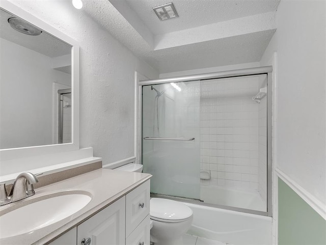 full bathroom featuring tile patterned floors, toilet, bath / shower combo with glass door, a textured ceiling, and vanity