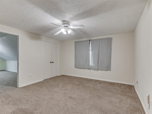 unfurnished room with ceiling fan, a textured ceiling, and carpet