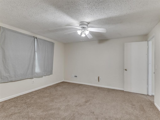 carpeted empty room with a textured ceiling and ceiling fan