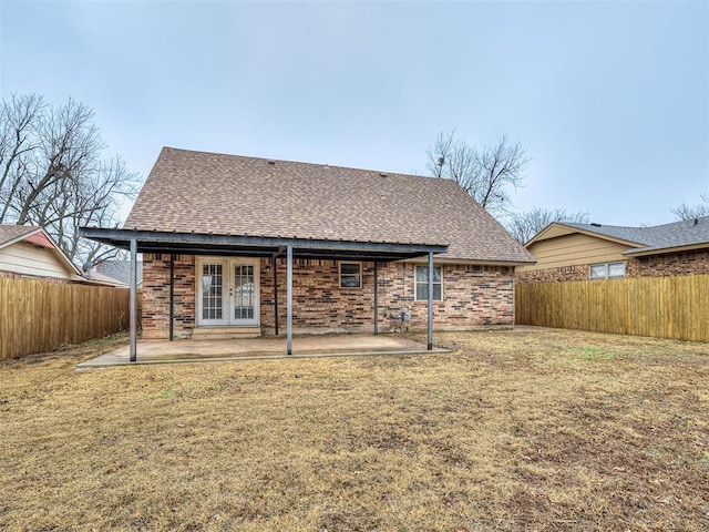 rear view of property featuring french doors, a yard, and a patio area