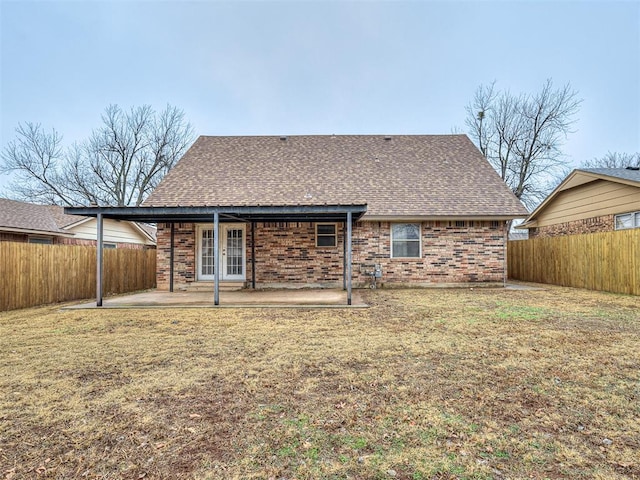 back of property with a lawn and a patio area