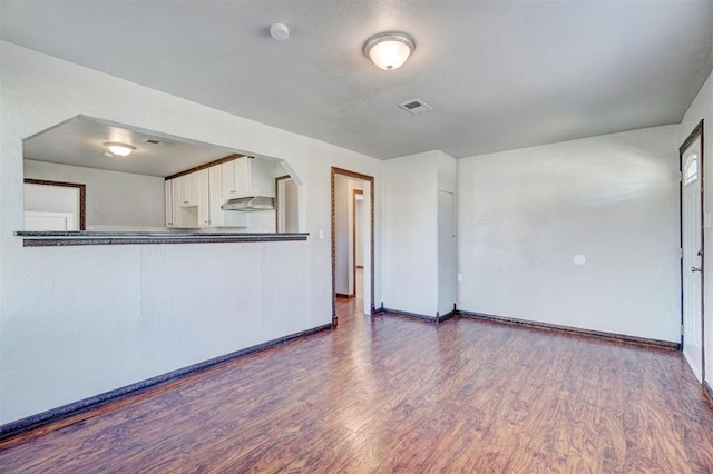 unfurnished living room with dark hardwood / wood-style floors