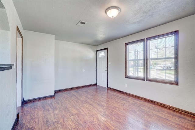 spare room with dark wood-type flooring and a textured ceiling