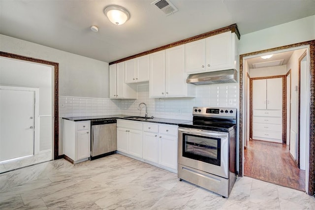 kitchen with white cabinetry, sink, exhaust hood, and appliances with stainless steel finishes