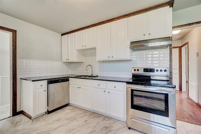 kitchen featuring white cabinetry, sink, decorative backsplash, stainless steel appliances, and wall chimney exhaust hood