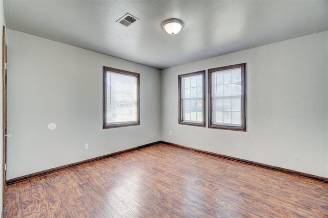 empty room with hardwood / wood-style flooring