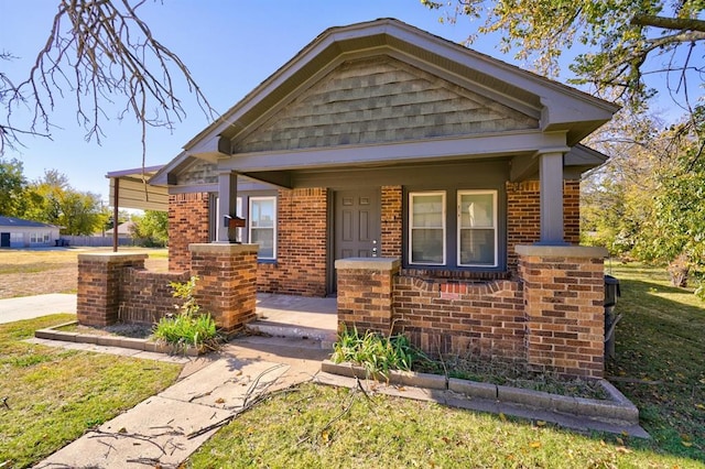 view of front of home featuring covered porch and a front lawn