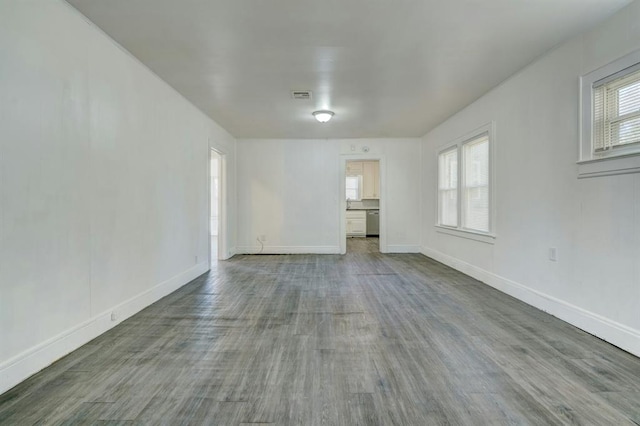 empty room with wood-type flooring and a healthy amount of sunlight