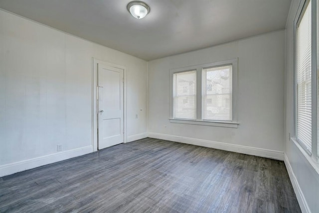 empty room featuring dark wood-type flooring and plenty of natural light