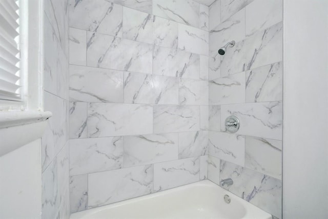 bathroom featuring tiled shower / bath