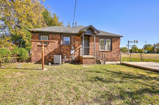 view of front of home featuring a front yard and central air condition unit