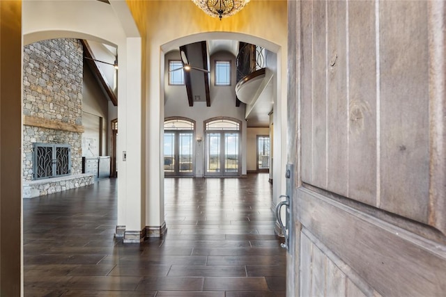 entrance foyer featuring dark hardwood / wood-style flooring, a fireplace, ceiling fan, and a high ceiling