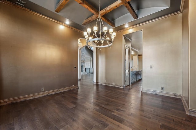 empty room featuring beamed ceiling, coffered ceiling, dark hardwood / wood-style flooring, and an inviting chandelier