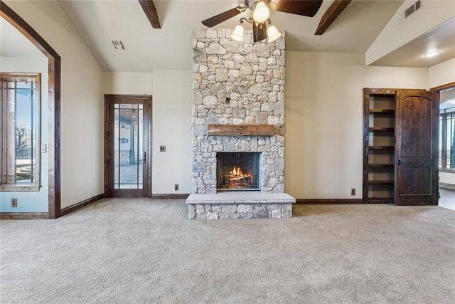 unfurnished living room with a fireplace, lofted ceiling with beams, and carpet