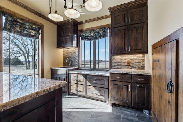 kitchen with crown molding, tasteful backsplash, hanging light fixtures, and dark brown cabinets