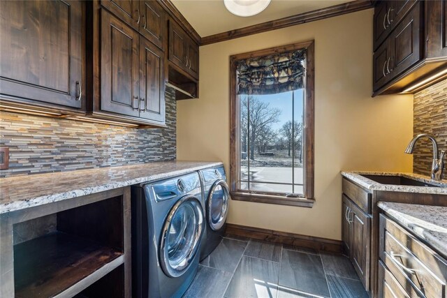 washroom featuring washing machine and dryer, sink, and ornamental molding