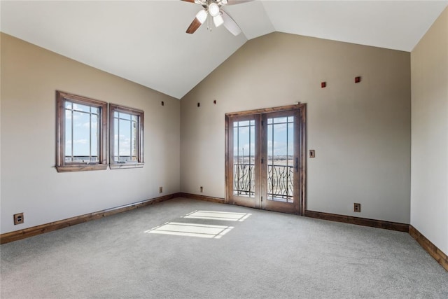 carpeted empty room with ceiling fan, a wealth of natural light, and high vaulted ceiling