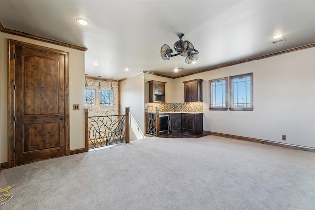 unfurnished living room featuring ornamental molding and carpet flooring