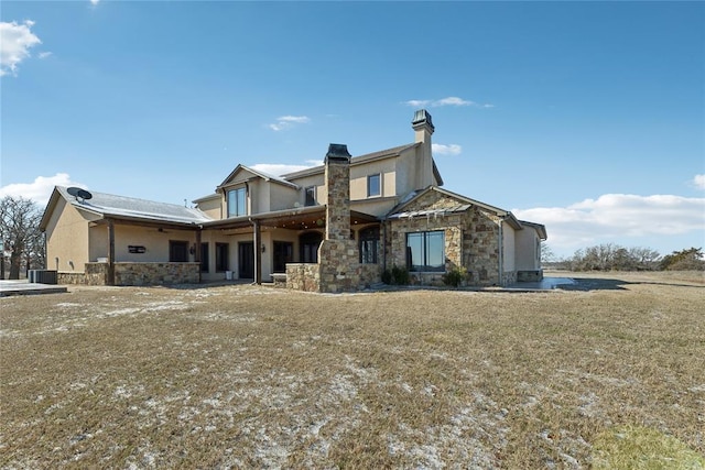 rear view of property with a yard and central air condition unit