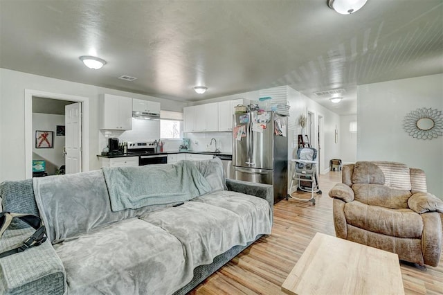 living room with sink and light hardwood / wood-style flooring