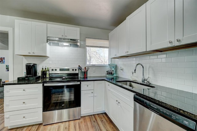 kitchen featuring sink, white cabinetry, tasteful backsplash, dark stone countertops, and stainless steel appliances