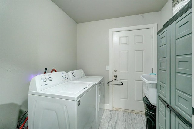 washroom with washing machine and dryer and light hardwood / wood-style flooring