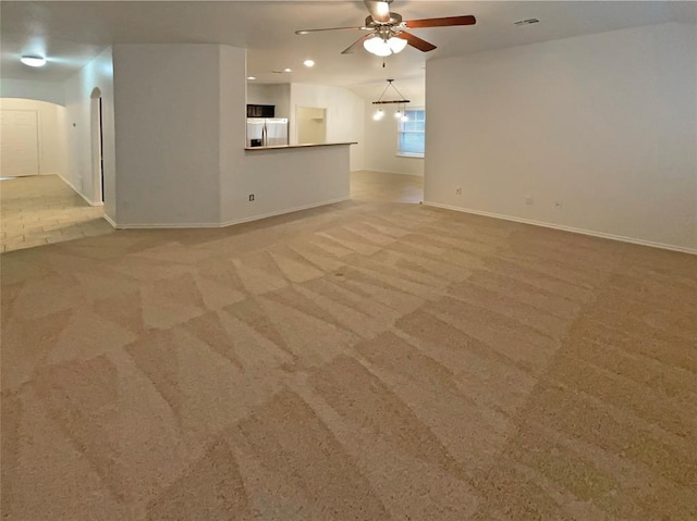 unfurnished living room with ceiling fan, lofted ceiling, and light colored carpet