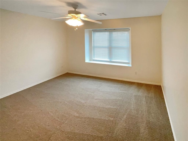 unfurnished room with ceiling fan and carpet