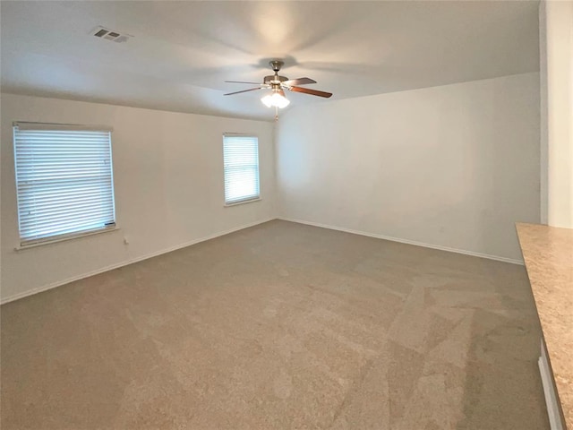 carpeted spare room featuring ceiling fan