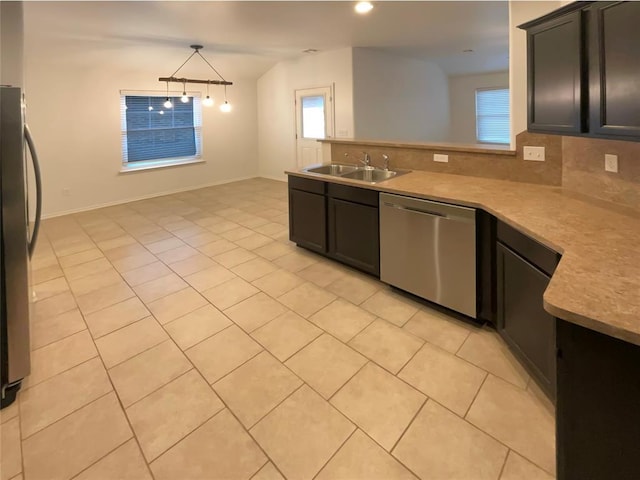 kitchen featuring appliances with stainless steel finishes, pendant lighting, sink, decorative backsplash, and light tile patterned floors