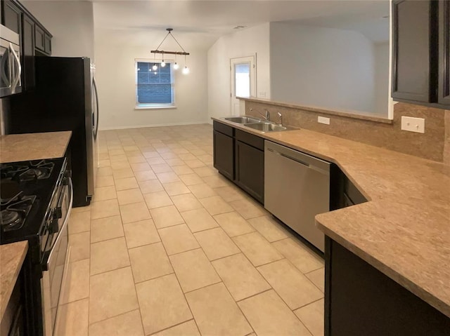 kitchen with stainless steel appliances, sink, hanging light fixtures, and backsplash