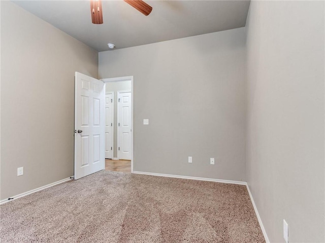 carpeted spare room with ceiling fan