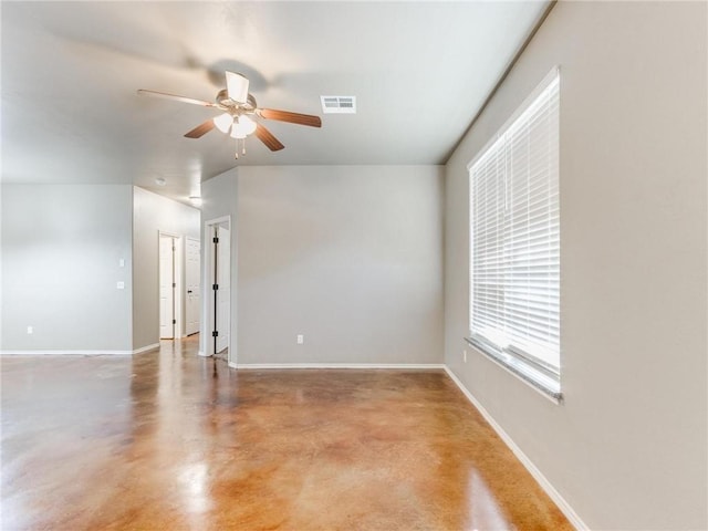 unfurnished room with ceiling fan and concrete flooring