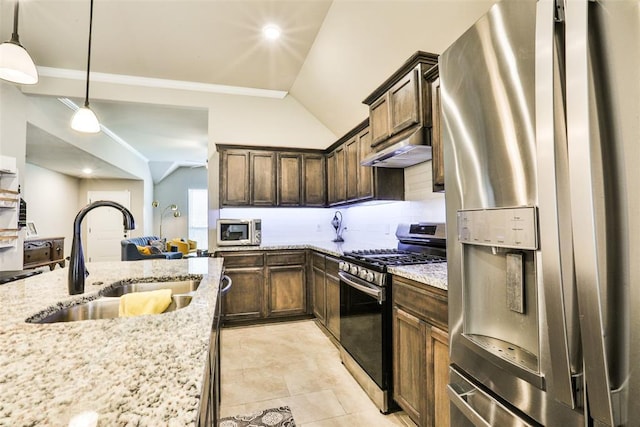 kitchen with light stone counters, appliances with stainless steel finishes, sink, and hanging light fixtures