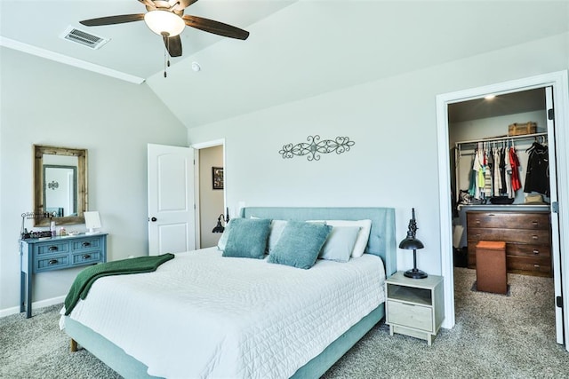 carpeted bedroom featuring a walk in closet, a closet, ceiling fan, and vaulted ceiling