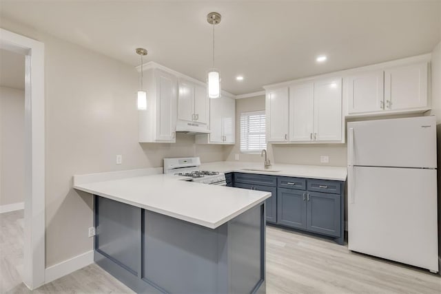 kitchen featuring sink, hanging light fixtures, kitchen peninsula, white appliances, and white cabinets