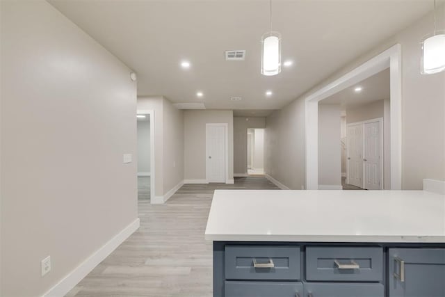 kitchen featuring decorative light fixtures, gray cabinets, and light hardwood / wood-style floors